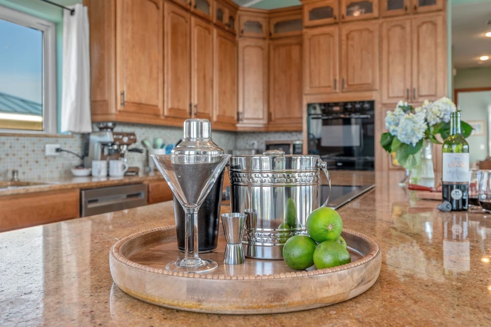 The spacious island boasts a convenient bar sink and undercounter refrigerator – your go-to destination for crafting your favorite cocktails and chilling your beverages.