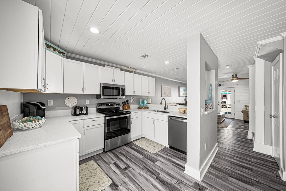 modern kitchen with stainless steel appliances and white cabinetry