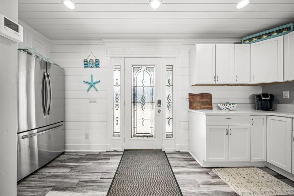 Entryway with decorative glass door and modern kitchen appliances
