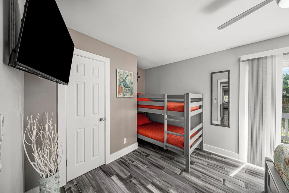 Modern bedroom with gray bunk beds and natural light from sliding doors