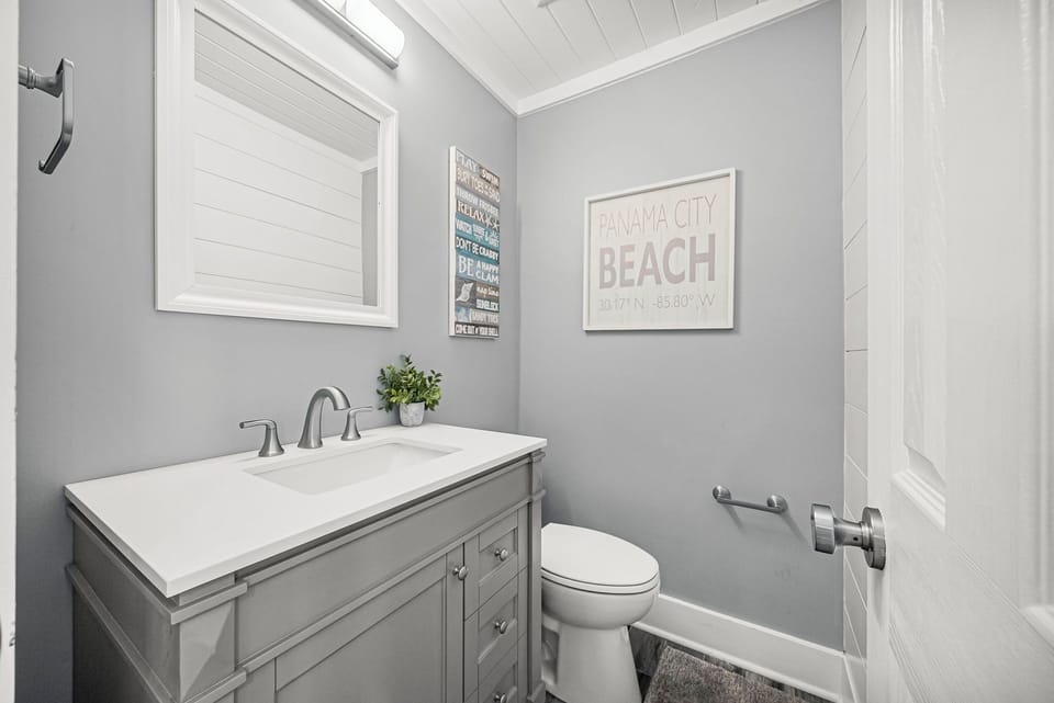 Modern bathroom with gray vanity and coastal-themed decor