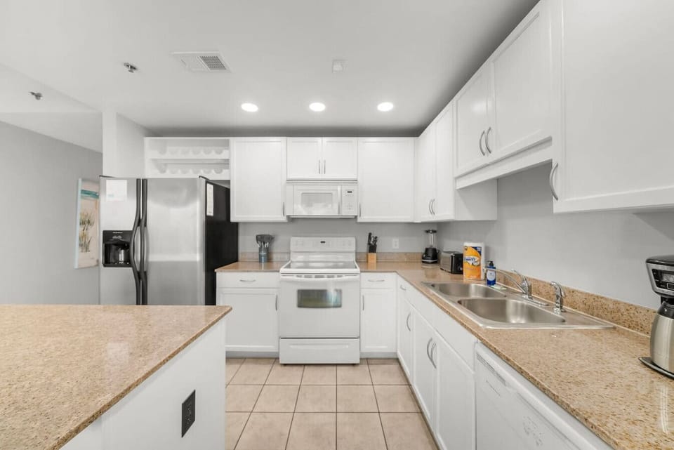 Fully Stocked Kitchen with Drip Coffee Maker and Island Bar Seating