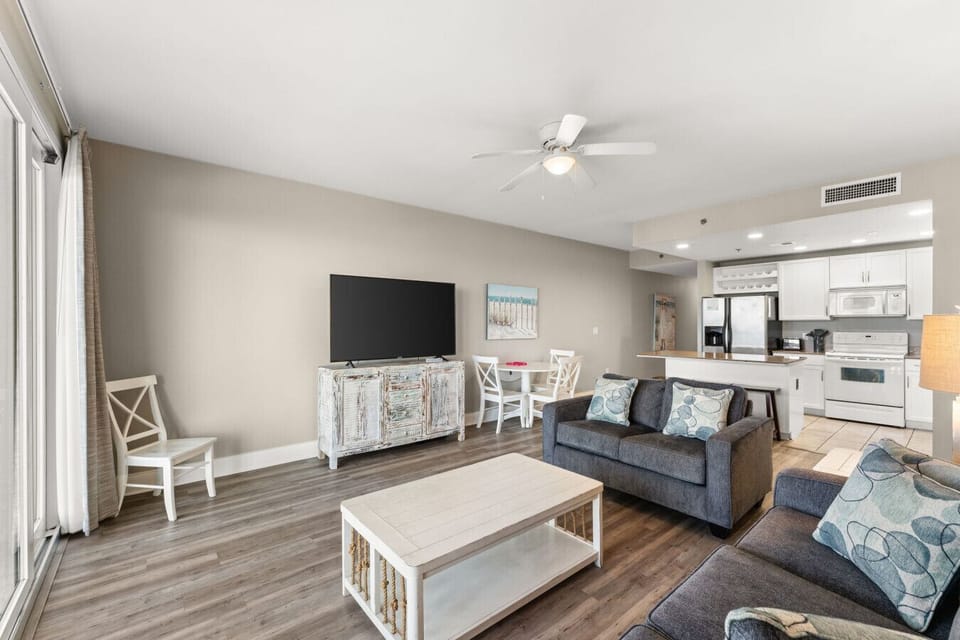 Ocean View Living Area with Sleeper Sofa, TV, Dining Table and Private Balcony Access