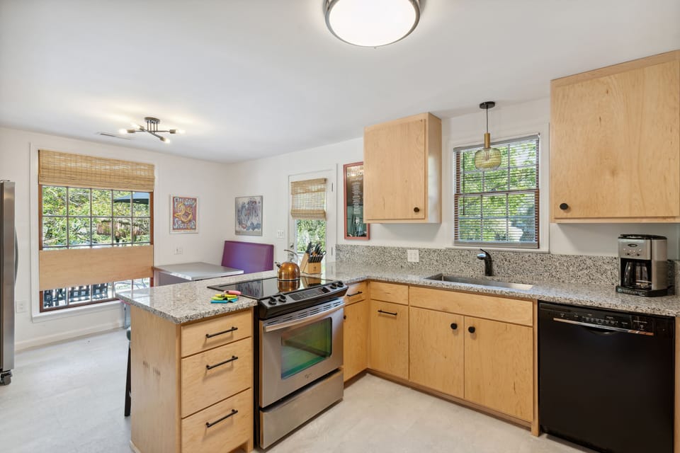 Full kitchen and modern appliances with a breakfast bar and dining area.