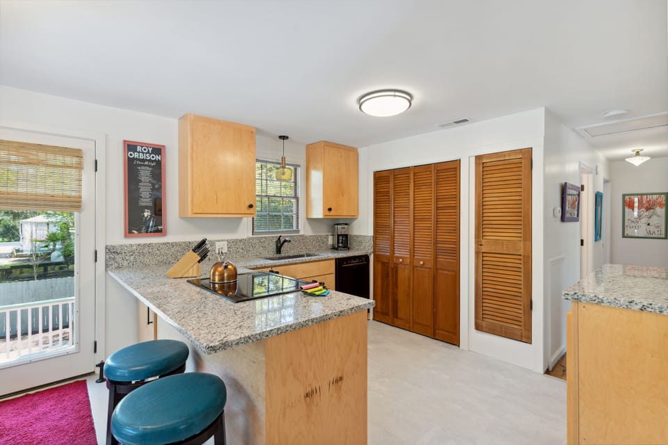 Full kitchen and modern appliances with a breakfast bar and dining area.
