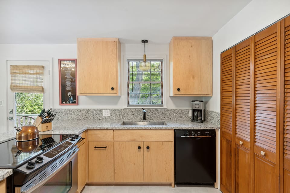 Full kitchen and modern appliances with a breakfast bar and dining area.