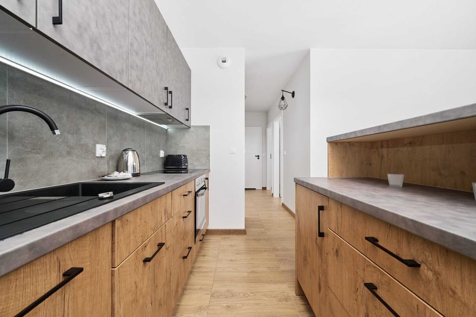 Kitchenette with electric hob, fridge, freezer, oven, kitchen utensils, kettle, toaster and dishwasher.