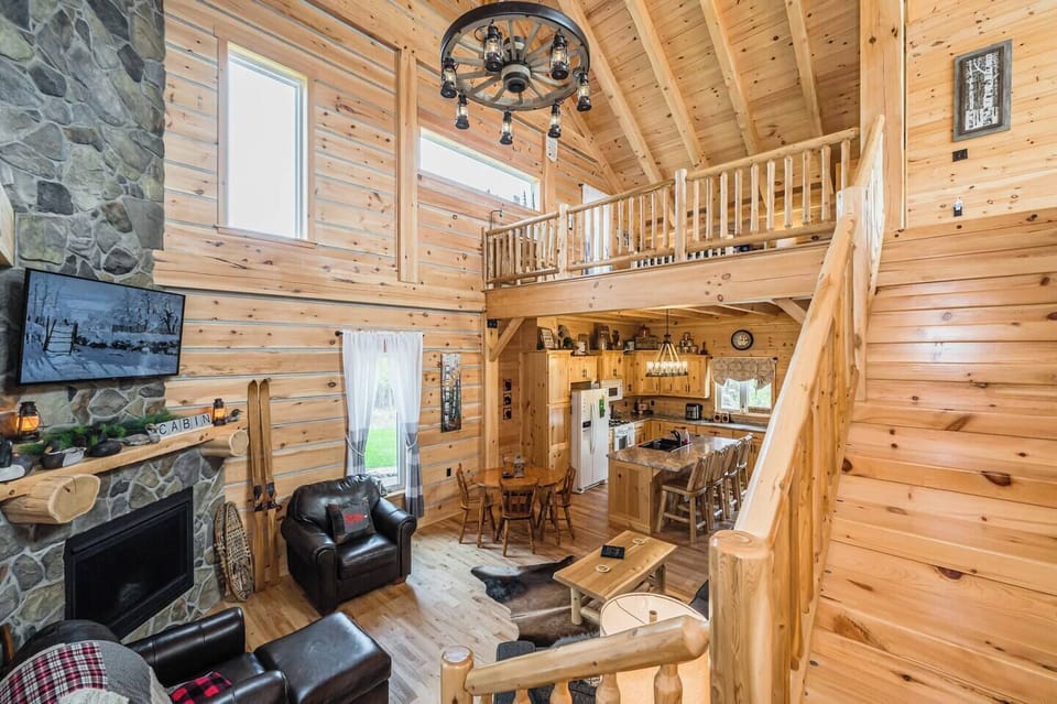 The Great room features comfortable furniture and rustic decor, with a fireplace and TV for warmth and entertainment. The stairway to the loft lounge 
