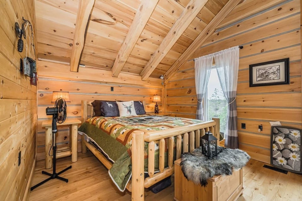 The loft bedroom not only offers a comfortable bed and rustic decor but also provides direct access to the balcony, inviting you to step outside and soak in the stunning natural surroundings.