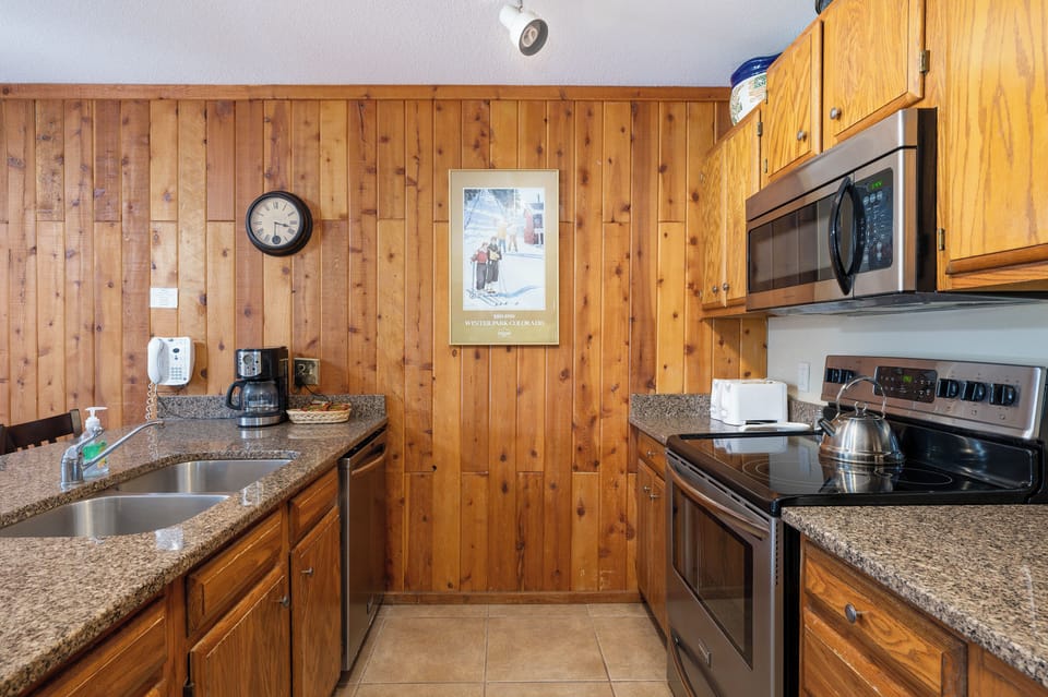Your fully equipped kitchen features granite countertops, stainless appliances, and warm wood cabinetry—perfect for preparing meals during your mountain getaway.