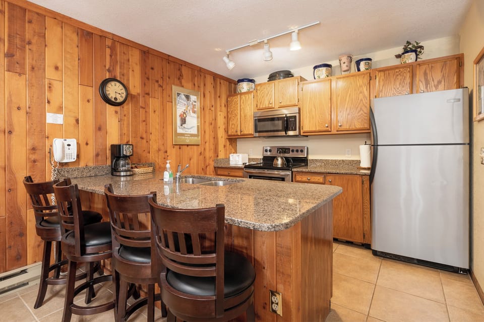 You'll love cooking in this warm kitchen with granite counters, full appliances, and cozy breakfast bar seating.