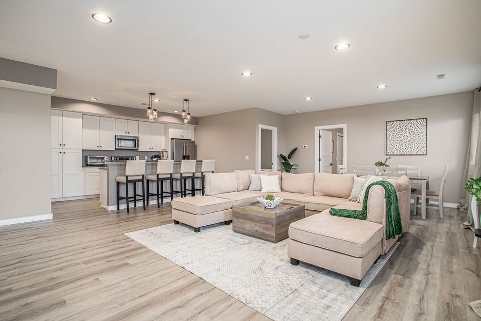 As you enter the living space, the large sectional catches your eye, providing ample seating for relaxation. The room is thoughtfully decorated with comfortable furnishings and stylish decor, creating a warm and inviting atmosphere for family and friends.
