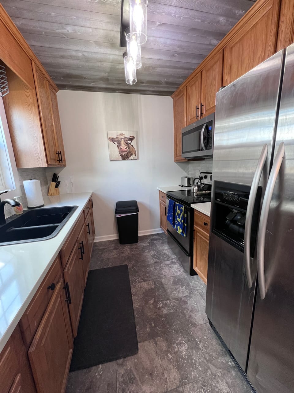 Well-supplied kitchen with natural wood ceiling, coffee bar