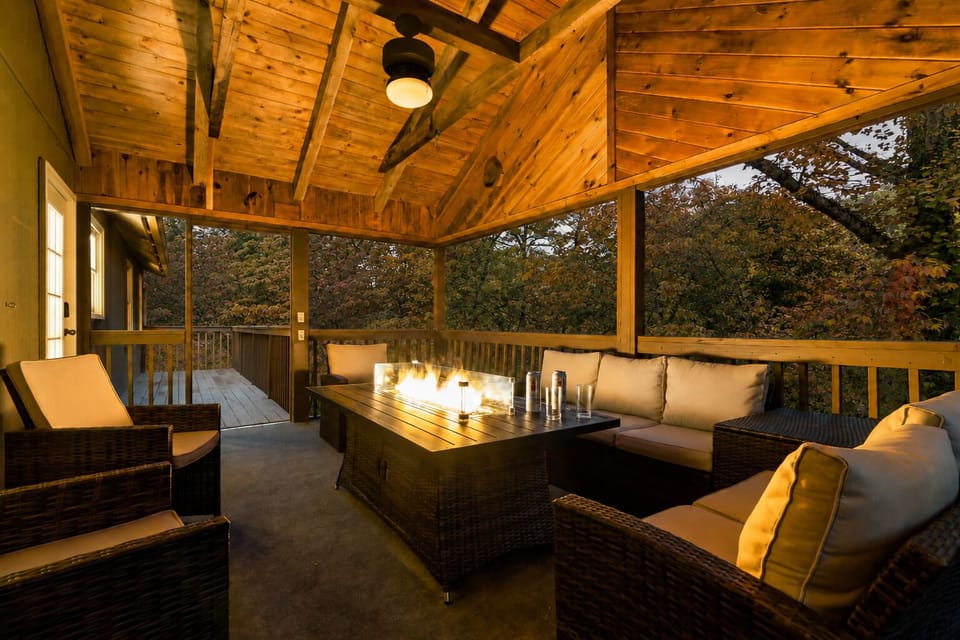 Secluded covered deck with a fire table; perfect for cozy evenings under the trees.