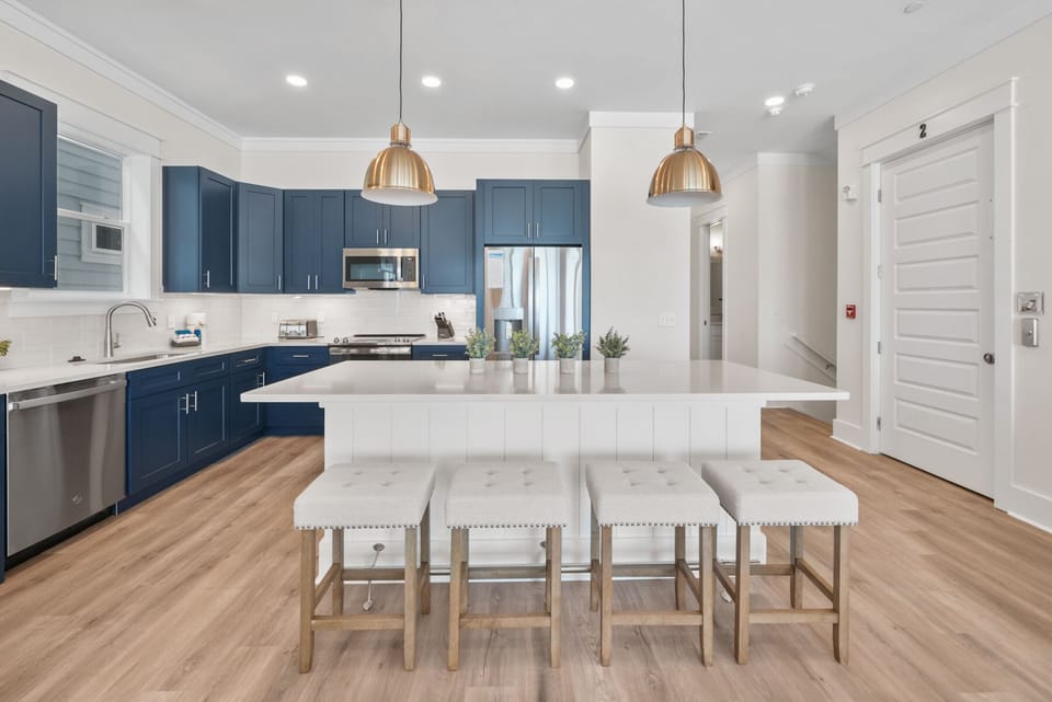 Your gourmet kitchen features navy blue cabinetry, quartz countertops, and a spacious island where you can gather for meals and memories.