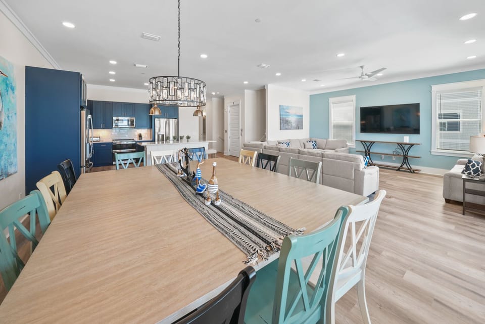 Gather around this spacious dining table where your group can share meals and make memories in this bright, coastal-inspired open living space.