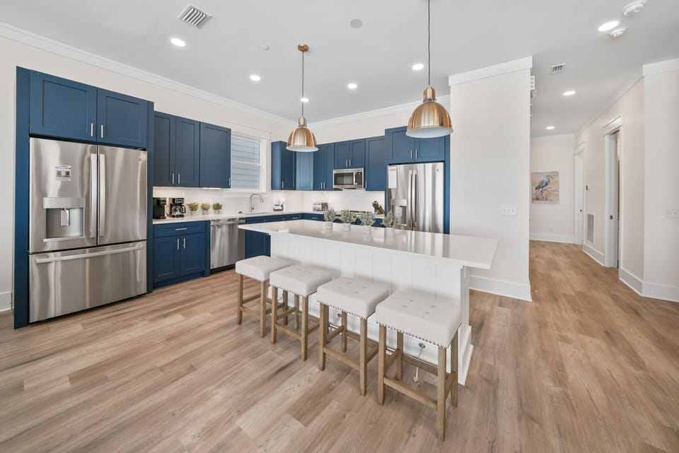 Your spacious kitchen features sleek navy cabinets, gleaming stainless appliances, and a stunning white island perfect for morning coffee or evening meals.