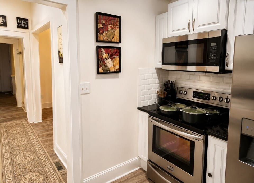 Everything you need for meals at home: a fully equipped kitchen with stainless steel appliances, cookware, and convenient prep space.