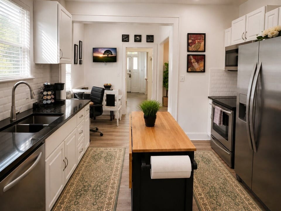 Bright, fully equipped kitchen with stainless steel appliances, ample counter space, cookware, coffee station, and a spacious island: everything you need to feel right at home.