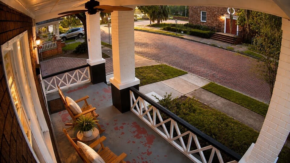 Enjoy the neighborhood from the front porch with rocking chairs and a peaceful view of the charming brick lined street.