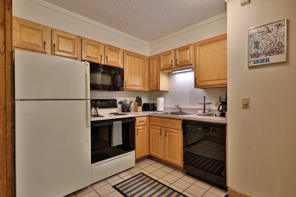 Experience the warmth of our well-equipped kitchen, featuring timeless wooden cabinets and a handy microwave for your convenience.