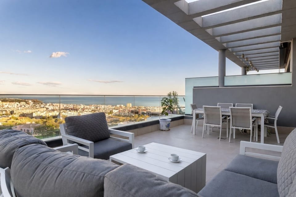 Ideal sunrise spot—penthouse terrace with lounge seating, mountain & sea views.