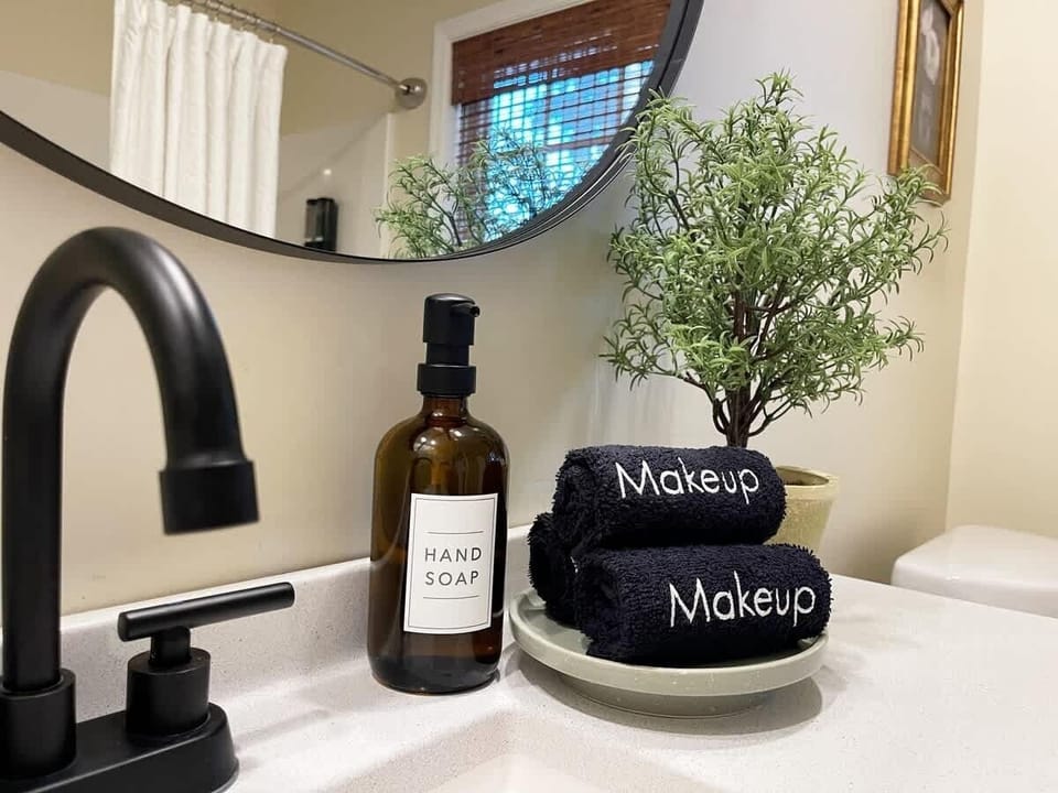 Practical and Stylish - Bathroom sink styled with dark makeup towels for your convenience, and complimented by minimalist decor. 