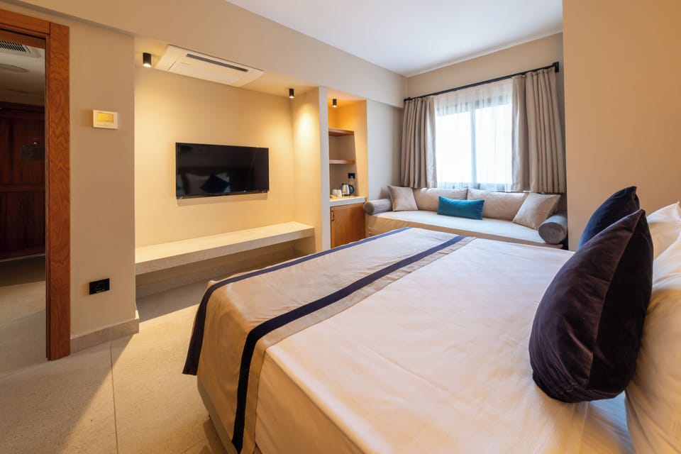 Deluxe Family Room | Minibar (free items), in-room safe, desk, laptop workspace