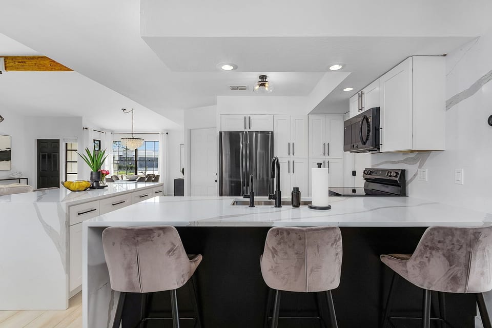 Full kitchen w/ island and black stainless steel appliances. 
