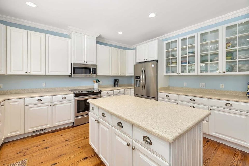 White kitchen with stainless appliances and center island