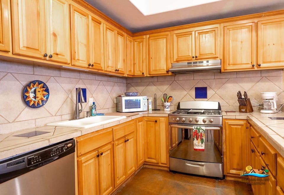 The kitchen at Casa Sonora features a gas stove, oven, microwave, large refrigerator, toaster, blender, and essential cookware .