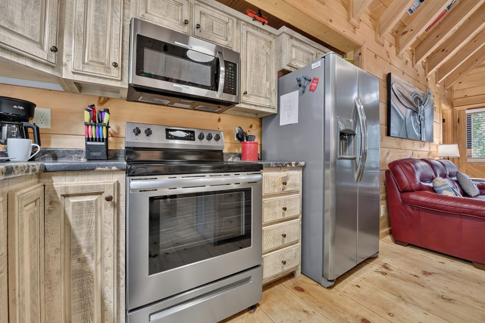 Cook up something special in this well-equipped North Georgia cabin kitchen, featuring stainless steel appliances, granite counters, and plenty of cabinet and workspace