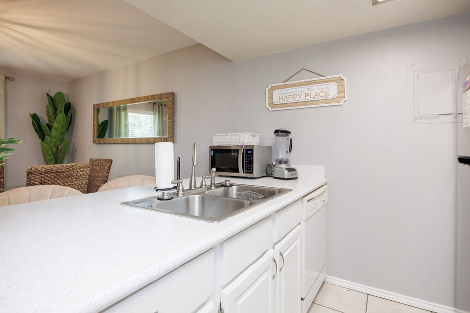 Your bright kitchenette awaits with everything you need—microwave, blender, and sink ready for easy meal prep in your happy place.
