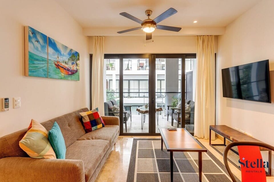 Your vibrant living room oasis! Comfy sofa, Smart TV & private terrace views await.


