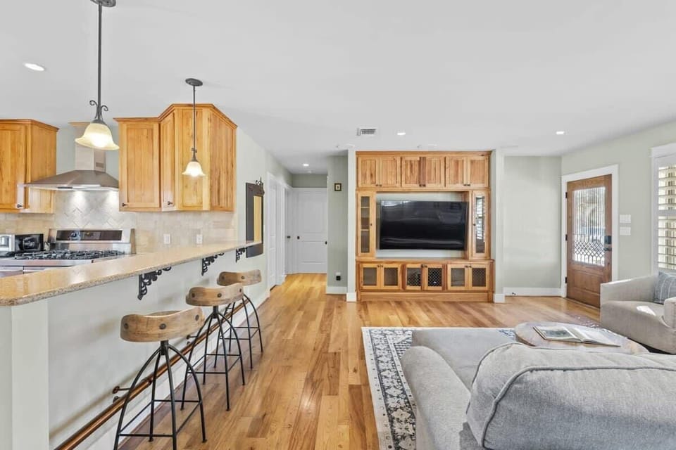 Living room and bar stools leading to two bedrooms down the hall.
