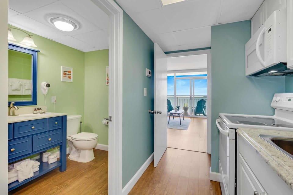 Enjoy a clean and inviting bathroom featuring updated fixtures, gentle lighting, and subtle coastal touches. Nestled between the living room and bedroom, it offers a refreshing retreat after a day at the beach.