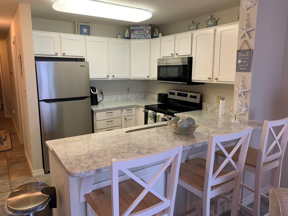 Kitchen includes eating area with 3 bar stools