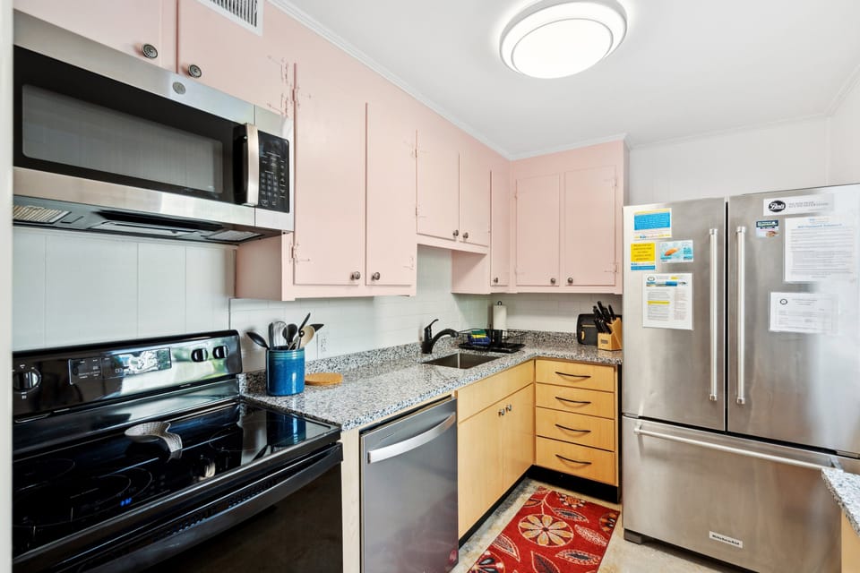 This kitchen includes large modern appliances in a vintage setting with a beautiful tiled floor and tiled backsplash.