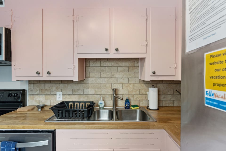 This kitchen includes large modern appliances in a vintage setting with a beautiful tiled floor and tiled backsplash.