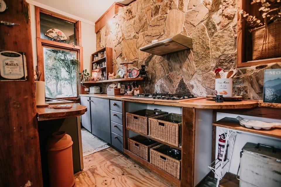 Rustic stone, timber, and cheerful details—a kitchen full of heart. (1)