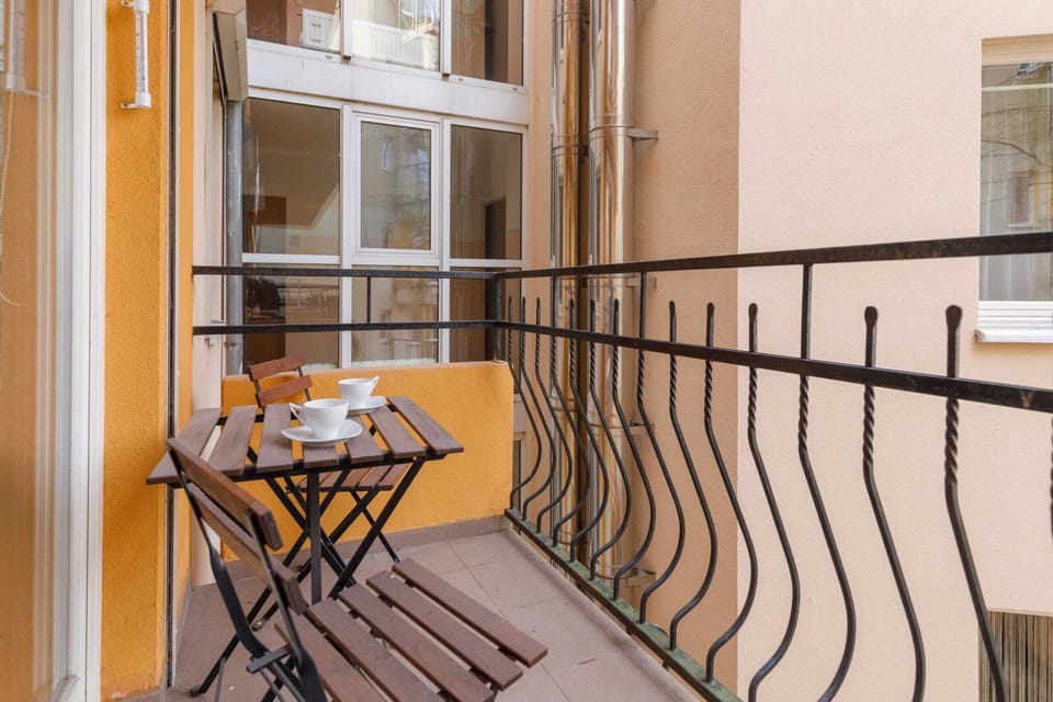 A small balcony with a table and chairs, perfect for enjoying a morning coffee.
