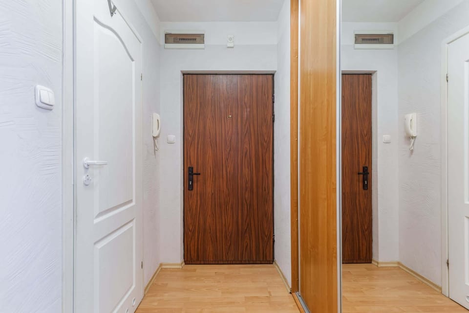 A hallway with wooden doors, offering access to the apartment’s rooms.
