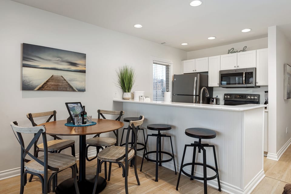 Open kitchen w/ breakfast bar & dining table, perfect for casual meals or working from home.