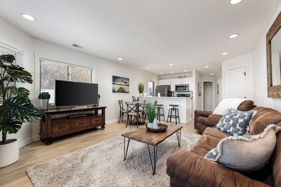 Cozy living room w/ comfy sofas, textured rug & open flow to the kitchen.