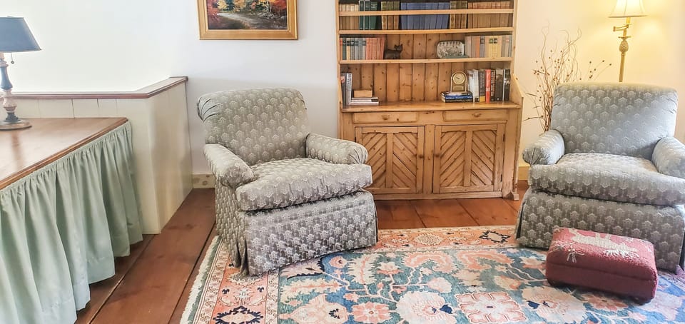 Upper level sitting area with armchair and built in storage.