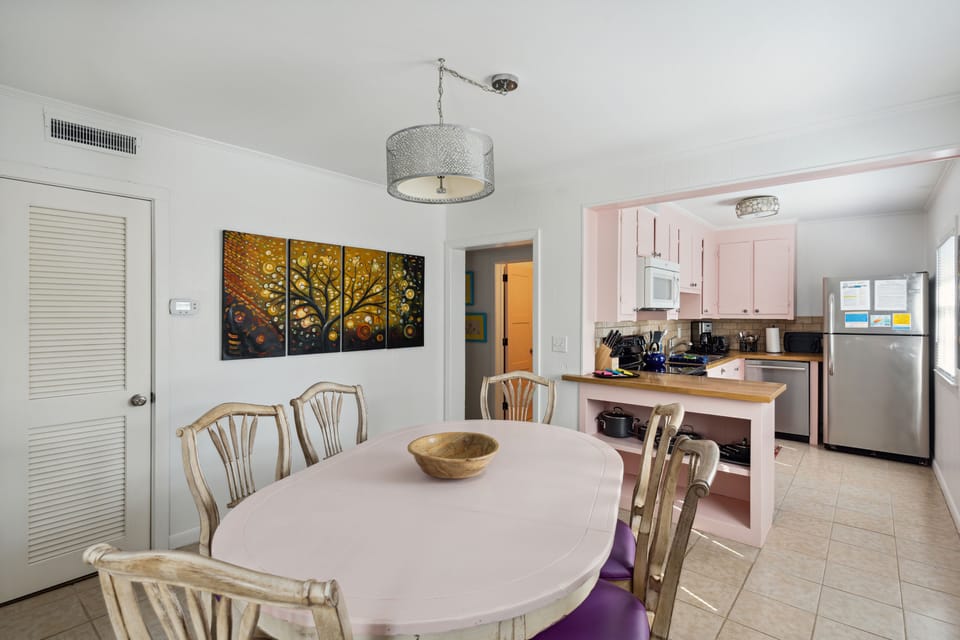 The dining area is well lit with unique wall art and a dining table that seats five. There is wonderful decorative lighting to illuminate the night and easy access to the kitchen and living areas.