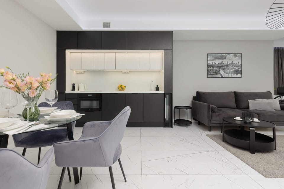 The same modern living area with additional details, including a chic chandelier and decorative elements on the walls, creating a cozy yet luxurious ambiance.

