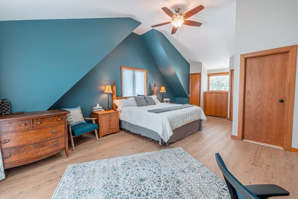Spacious primary bedroom with ensuite bathroom, workspace and balcony