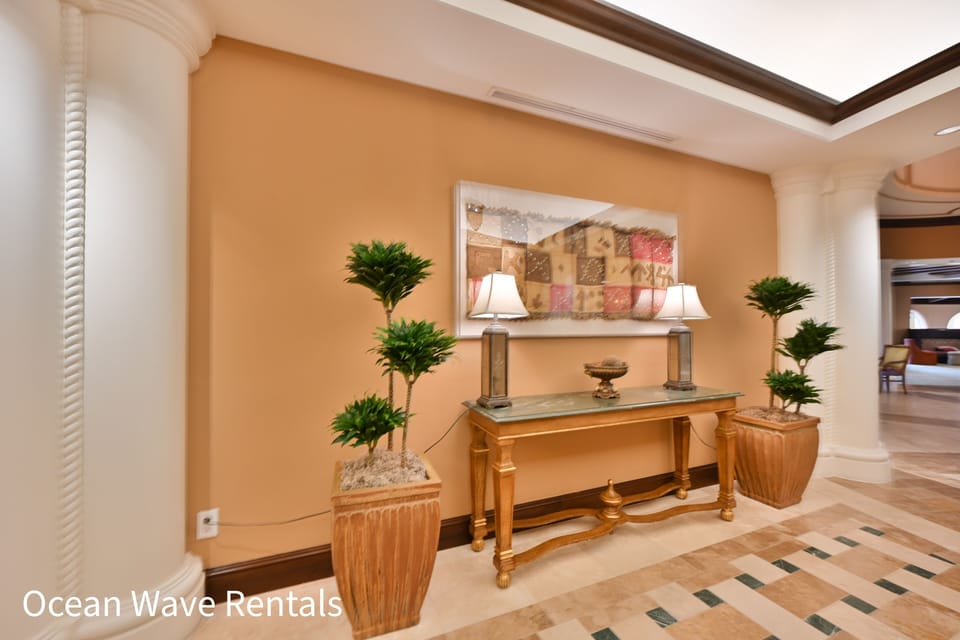 Elegant hallway with console table, decorative plants, and warm ambient lighting