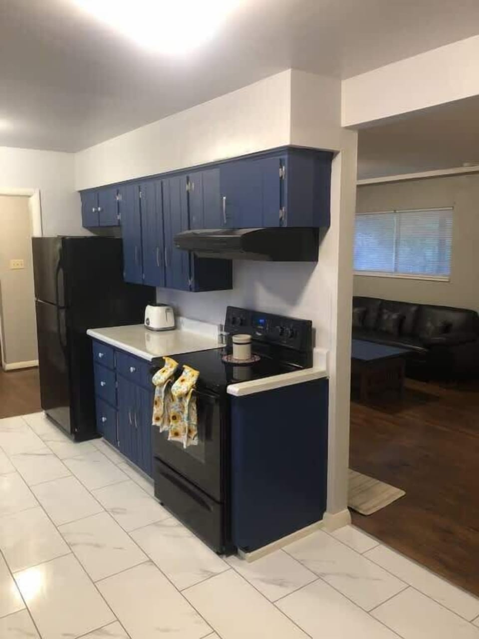 Kitchen with full size oven, fridge, and hood vent